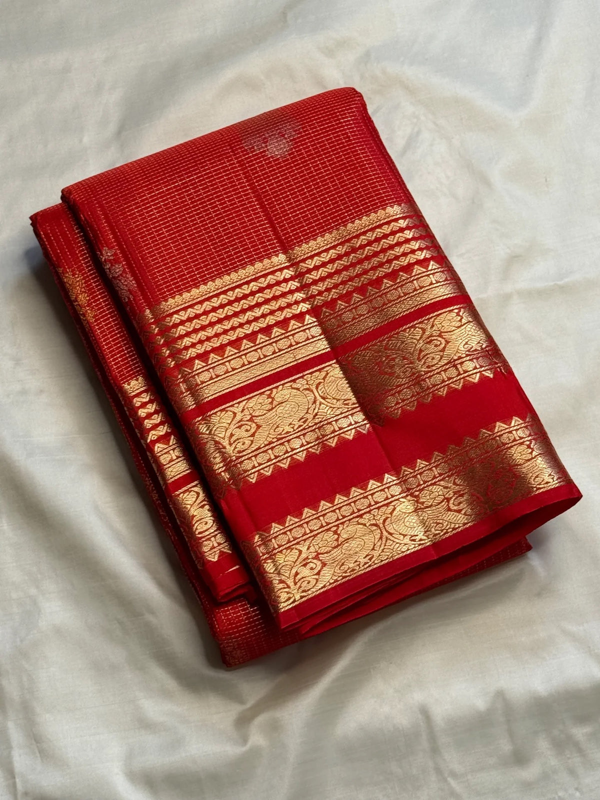 Vermilion red Pure Silk Kanchipuram saree with fine zari lattice and alternating gold and silver-toned buttas.