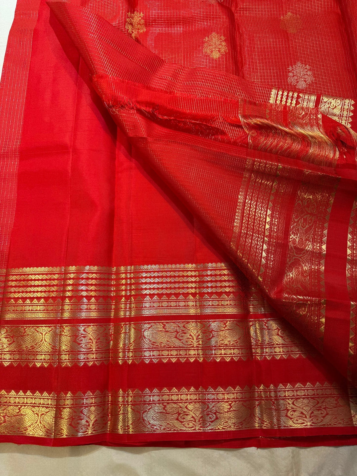 Close view of alternating Sona Rupa buttas positioned within the fine zari-grid silk body.