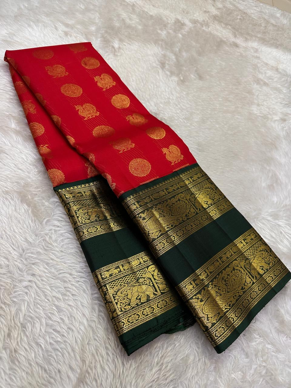 Vermilion red Pure Silk Kanjivaram saree draped, showing oversized mayil and kamalam buttas