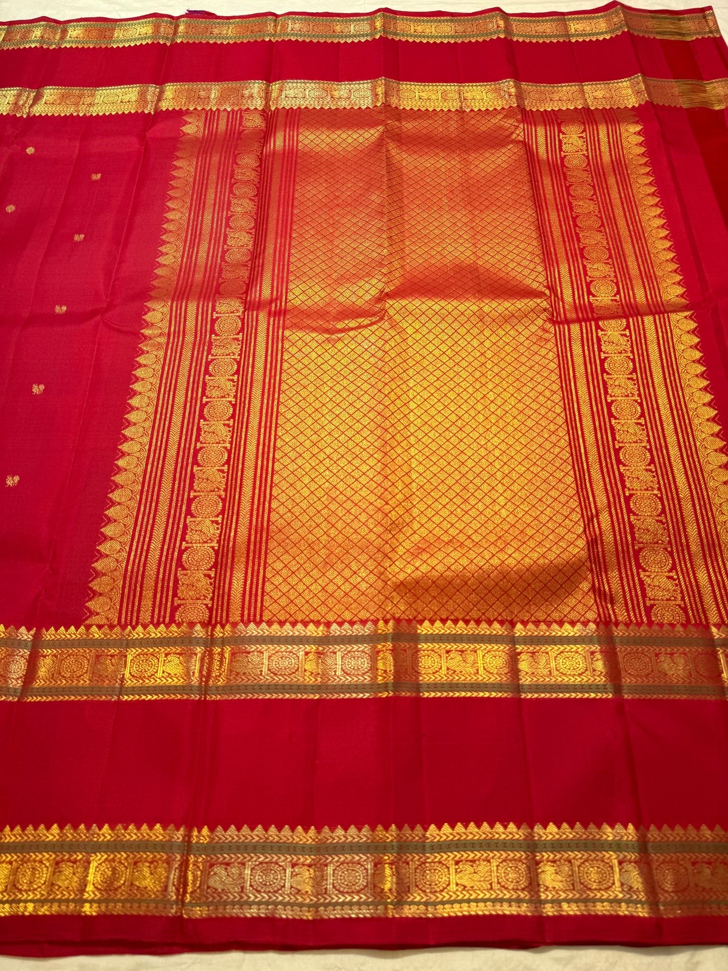 Vermilion Red pure silk Kanjeevaram Rettapet saree with spaced gold zari buttas and traditional gold border.