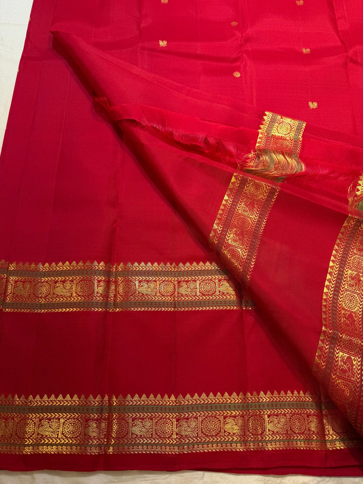 Close view of traditional gold zari ornamental motifs on Vermilion Red Rettapet border.