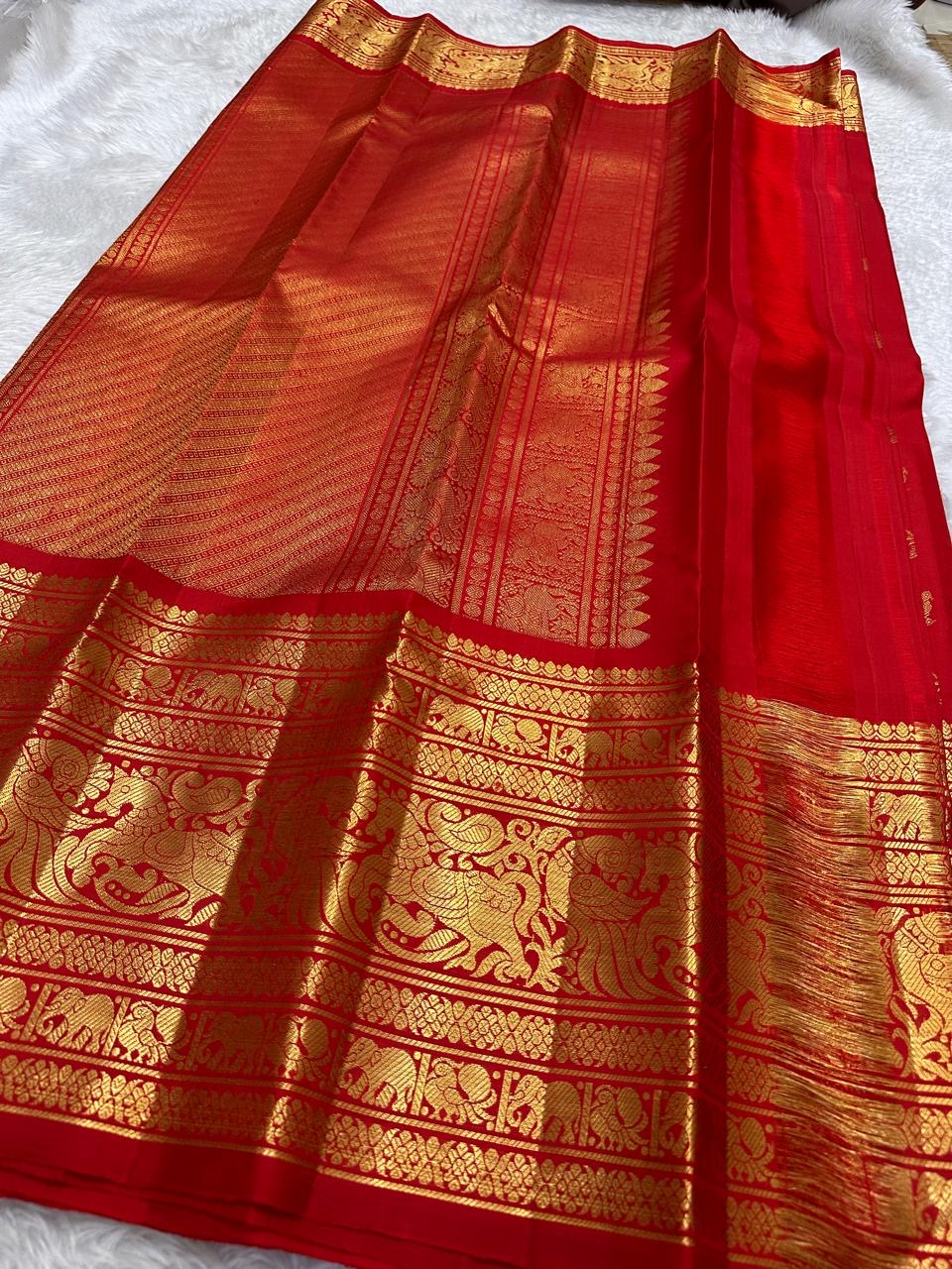 Kanchipattu silk saree in vibrant kumkum red with antique gold border Vanasringaram weave traditional zari detail