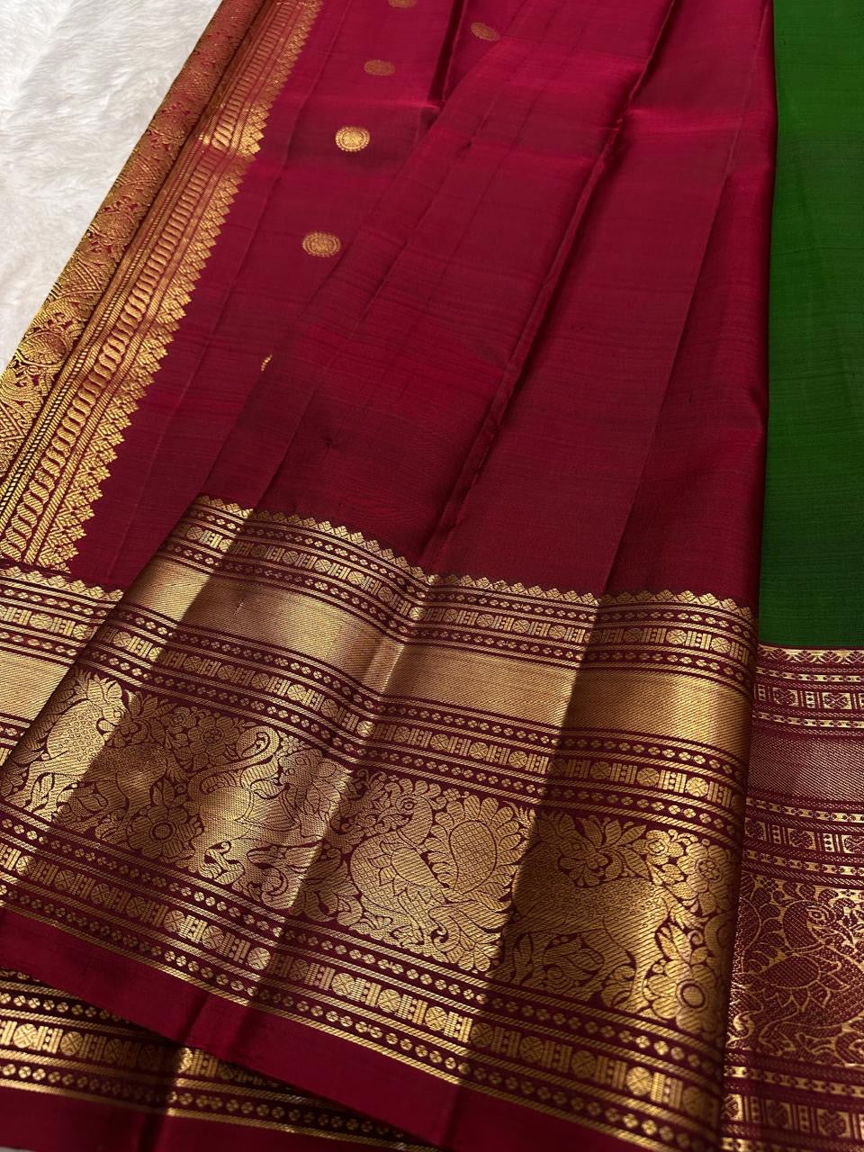 Close view of a Yaanai Ambari gold-zari butta on vintage green Kanchipuram silk.