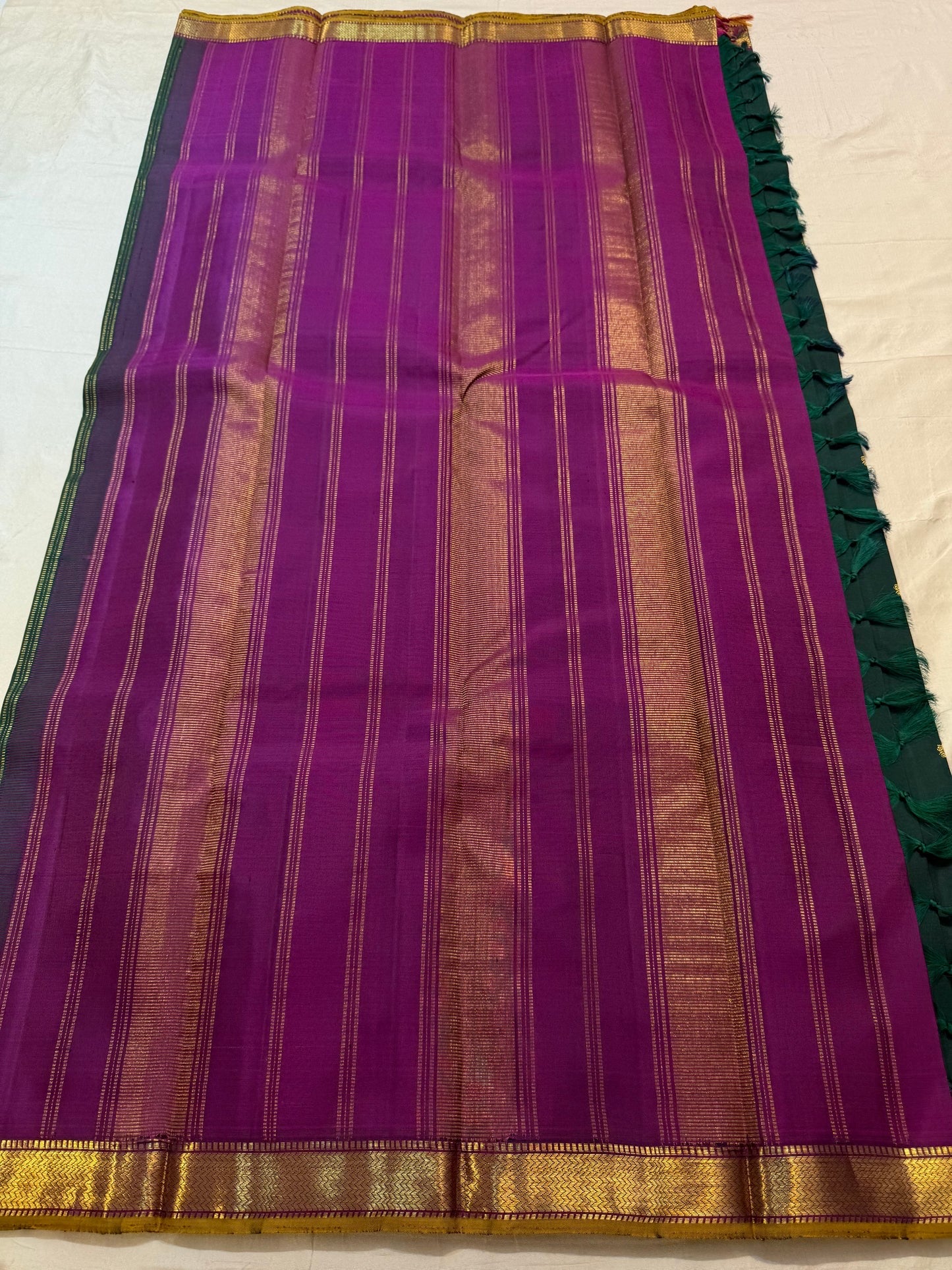Gold zari border detail with Neli chevron pattern on emerald green Kanchipuram saree