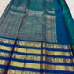 Neelam royal blue Varisaipet border with wide gold zari bands and peacock imagery on a magenta Kancheepuram saree