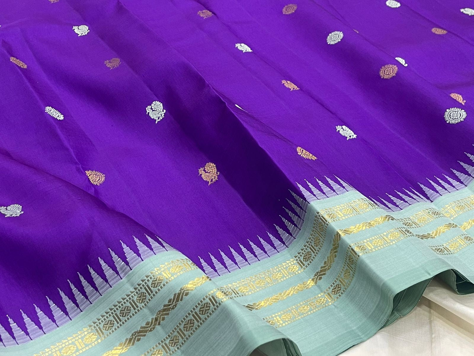 Royal violet blue Kanjeevaram silk saree body close-up showing Mayil Chakram circular peacock medallion buttas in silver zari