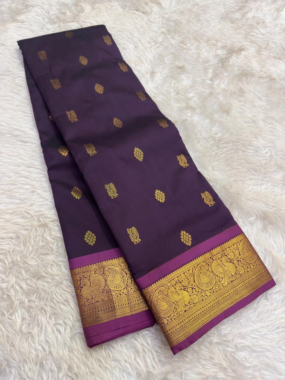Imperial violet silk saree with classic gold zari motifs and peacock border