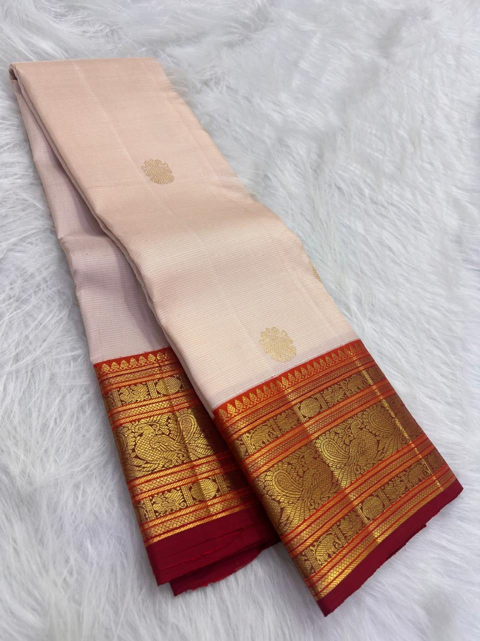 Warm Ivory pure silk Kanjeevaram Varisaipet saree with Arakku Red and antique-gold zari border.