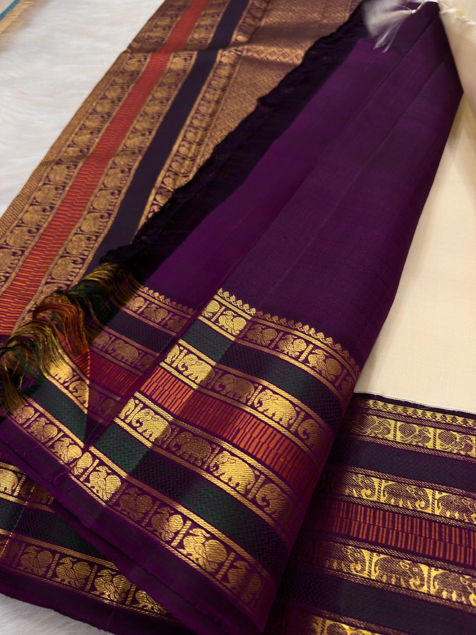 Warm Ivory Pure Silk Kanchipuram Varisaipet saree with petite gold buttas and aubergine multi-motif zari border.