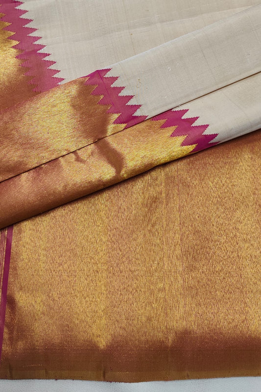 Warm Ivory pure silk Kanjivaram Ettukol saree with Rani Pink temple edge and antique-gold zari border.