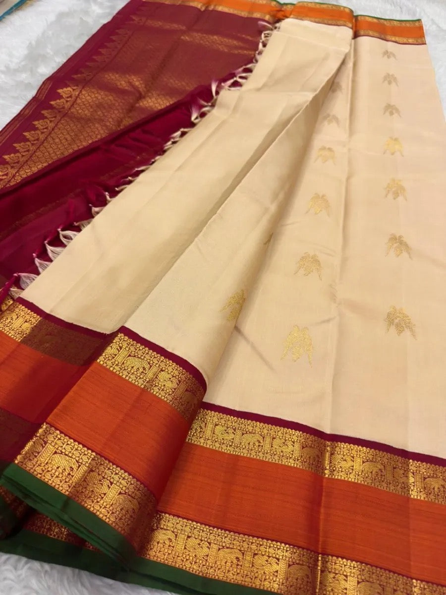 Deep maroon Kanchipuram silk pallu densely woven with traditional repeating gold zari patterns.