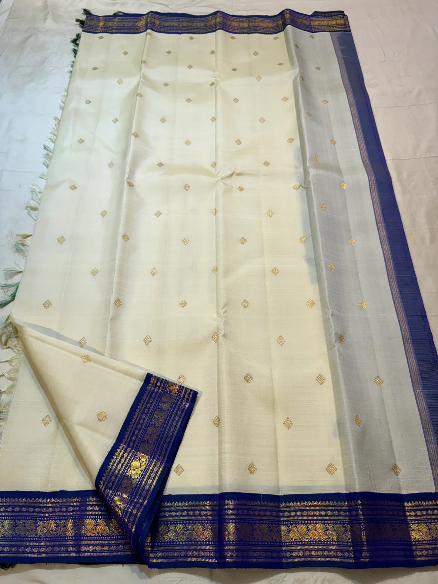 Warm Ivory pure silk Kanjivaram Korvai saree with Mayil Kazhuthu blue-green gold zari border.