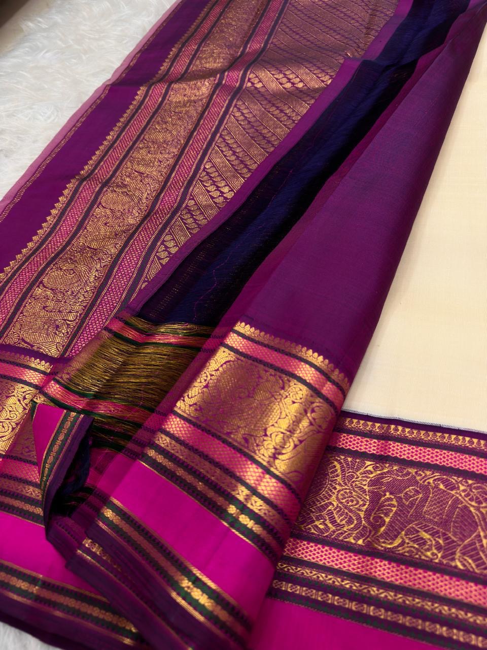 Close view of a gold zari flower-bunch butta woven with paisley detailing on Warm Ivory silk.