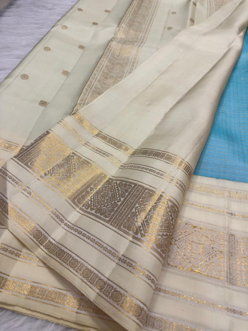 Warm Ivory Kanchipuram silk showing detailed geometric metallic zari border and delicate woven buttas.