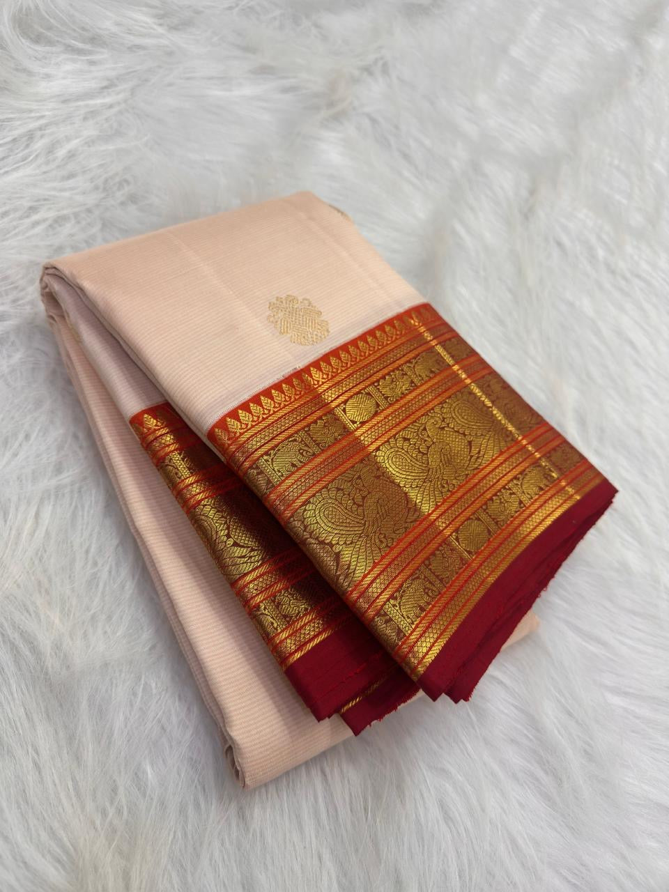Ivory Kanchipuram silk saree with spaced antique-gold zari motifs and layered red Varisaipet border.