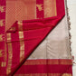 Folded view of warm ivory Korvai saree with rani pink zari border