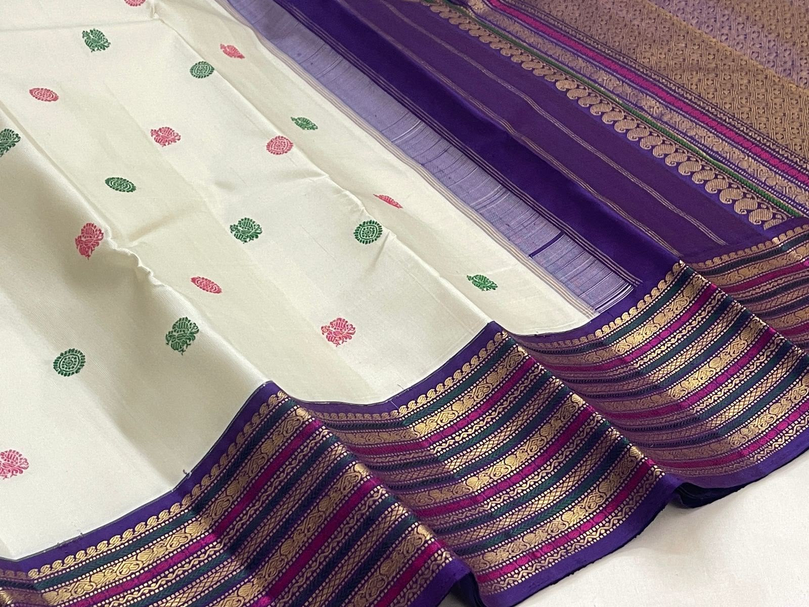 Handwoven ivory Kanchipuram silk saree with pink and green silk thread buttas