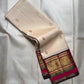 Warm Ivory pure silk KanchiPattu Butta saree with Vadamalli Magenta and gold zari border, shown folded.