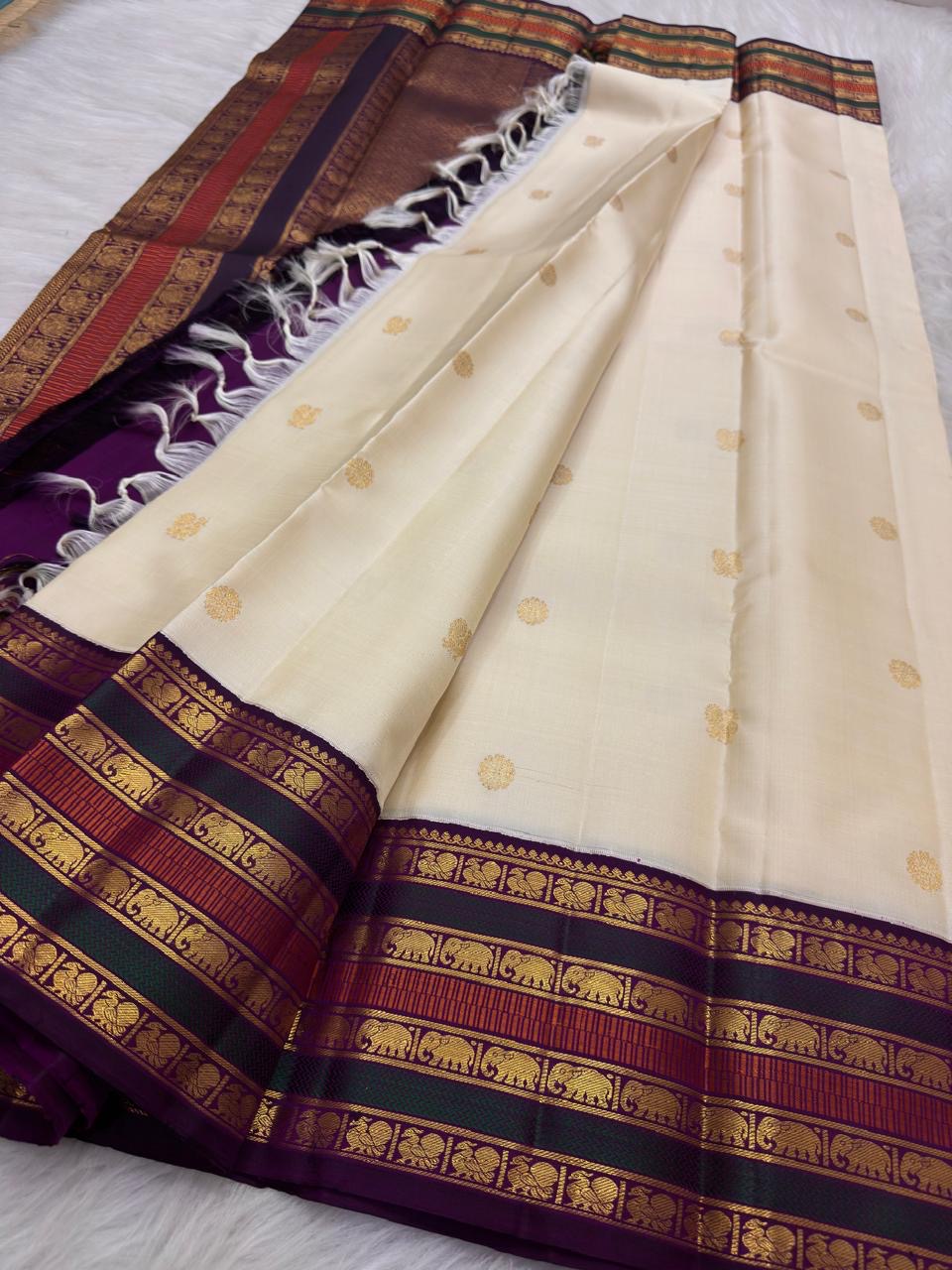 Warm Ivory Kanchipuram silk opened to show petite zari buttas and stacked elephant gold zari border.