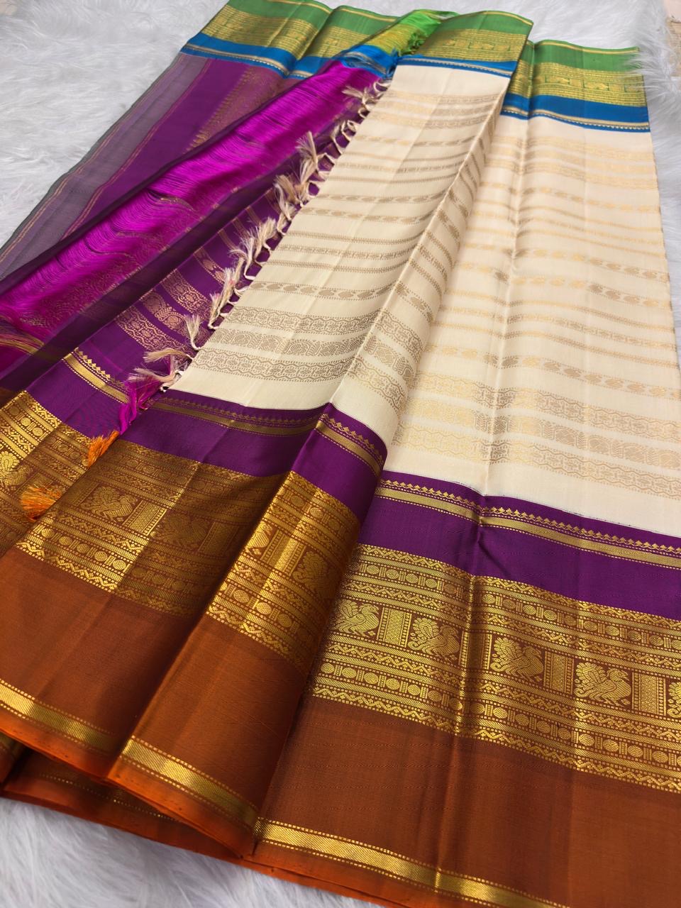 Purple VarnaJaalam Kanchipuram pallu densely handwoven with gold zari geometric patterns and ornate border registers.