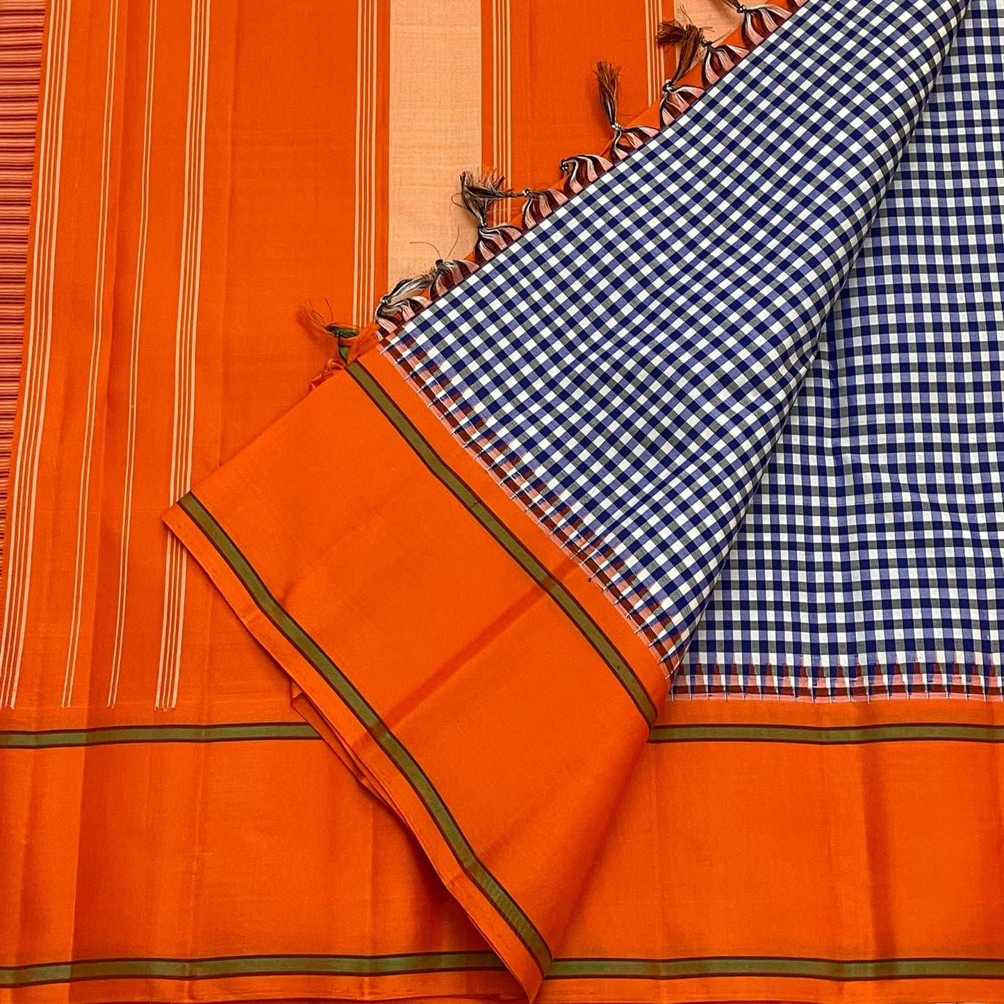 Navy white kattam and orange Kancheepuram silk saree folded showing Kanchi Kattam check body and contrast orange Korvai border