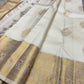 Flat lay of ivory Pure Kanchipuram Silk Saree with gold zari border and scattered gold motifs.