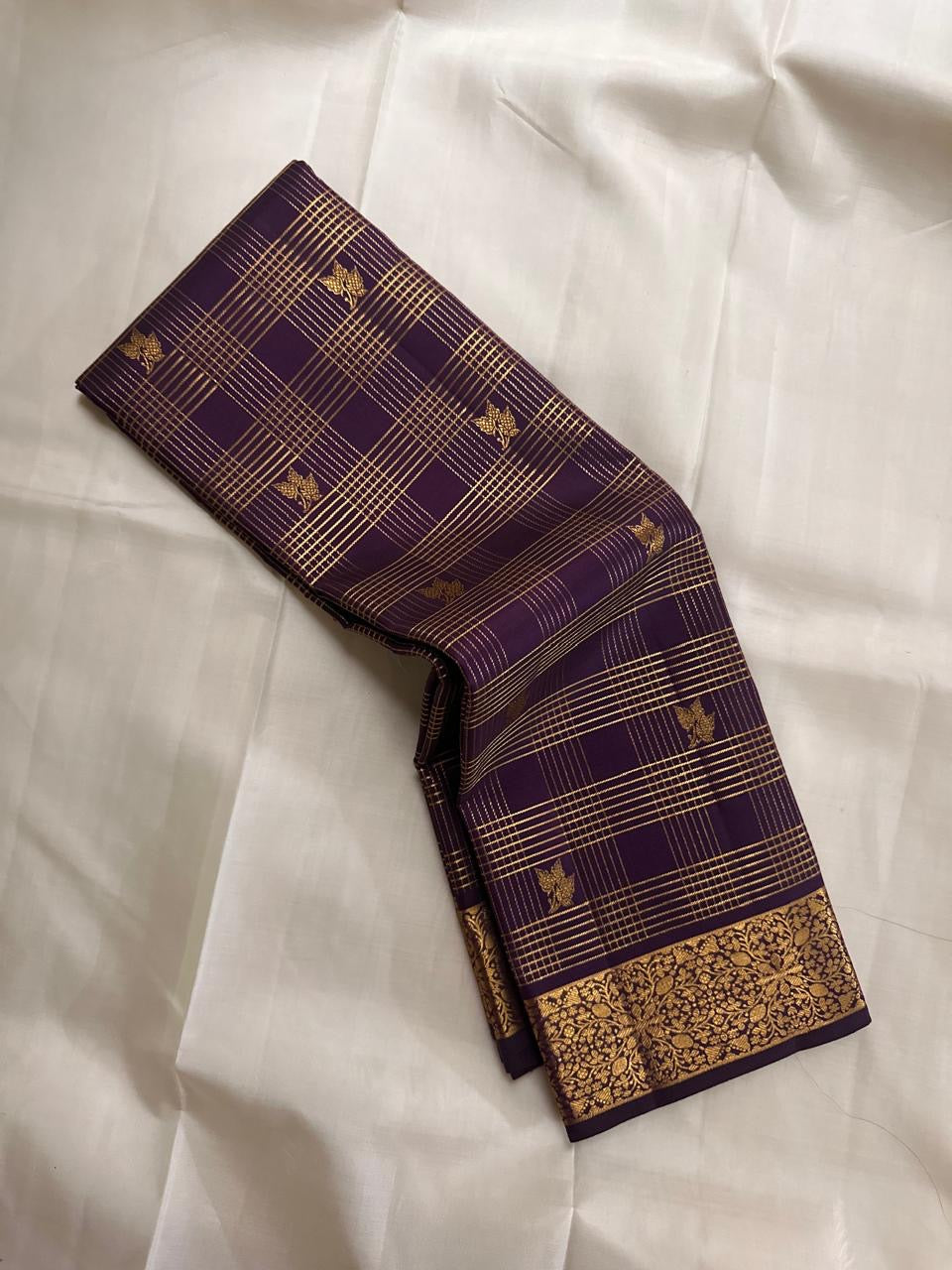 Close-up of wine purple Kancheepuram silk saree border showing dense floral jaal gold zari weaving — Idam Living