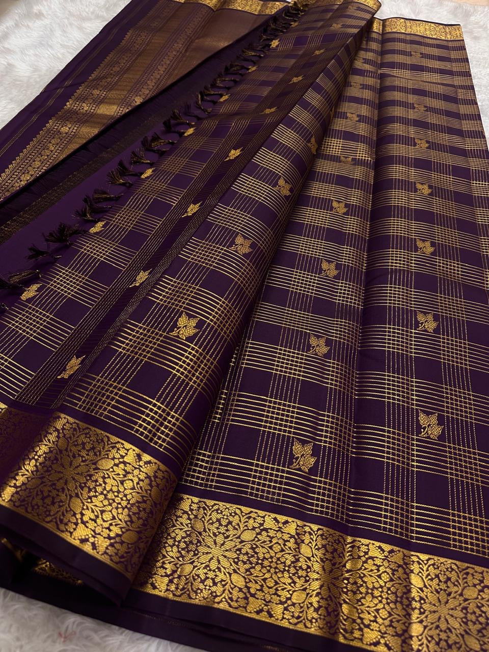 Wine purple Kanchi Pattu Zari Kattam saree folded flat showing gold check weave with Kili butta detailing — Idam Living