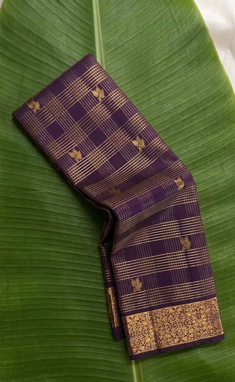 Wine purple Zari Kattam Kanchipuram silk saree rolled showing gold check body with Kili butta and floral border — Idam Living