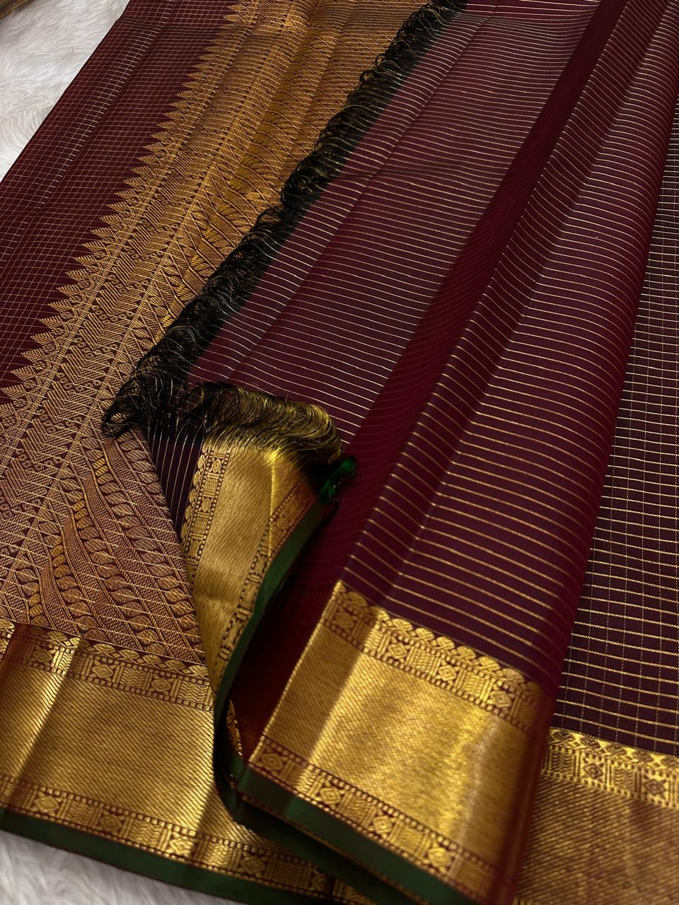 Thick antique gold zari woven border with floral and geometric motifs on burgundy deep coffee brown Kanjeevaram saree