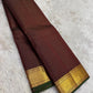 Diagonal zari woven pallu in antique gold cascading across burgundy deep coffee brown silk ground