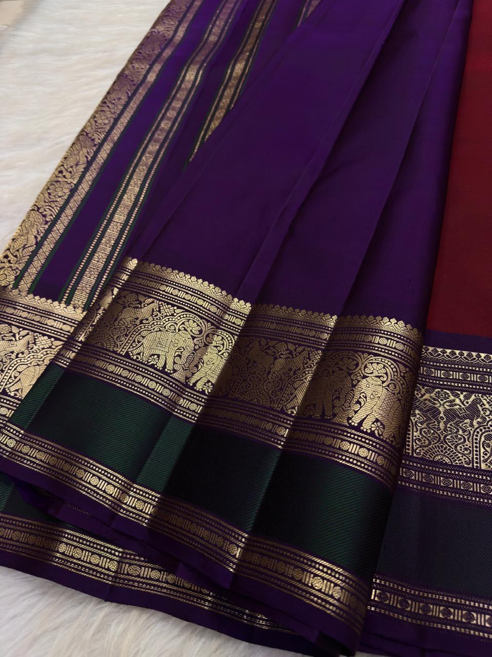 Yaanai and floral gold-zari ornament within the richly worked contrast border.