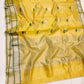 Turmeric Yellow handloom Chanderi saree with repeating silver flowers, green stems and broad pale metallic pallu