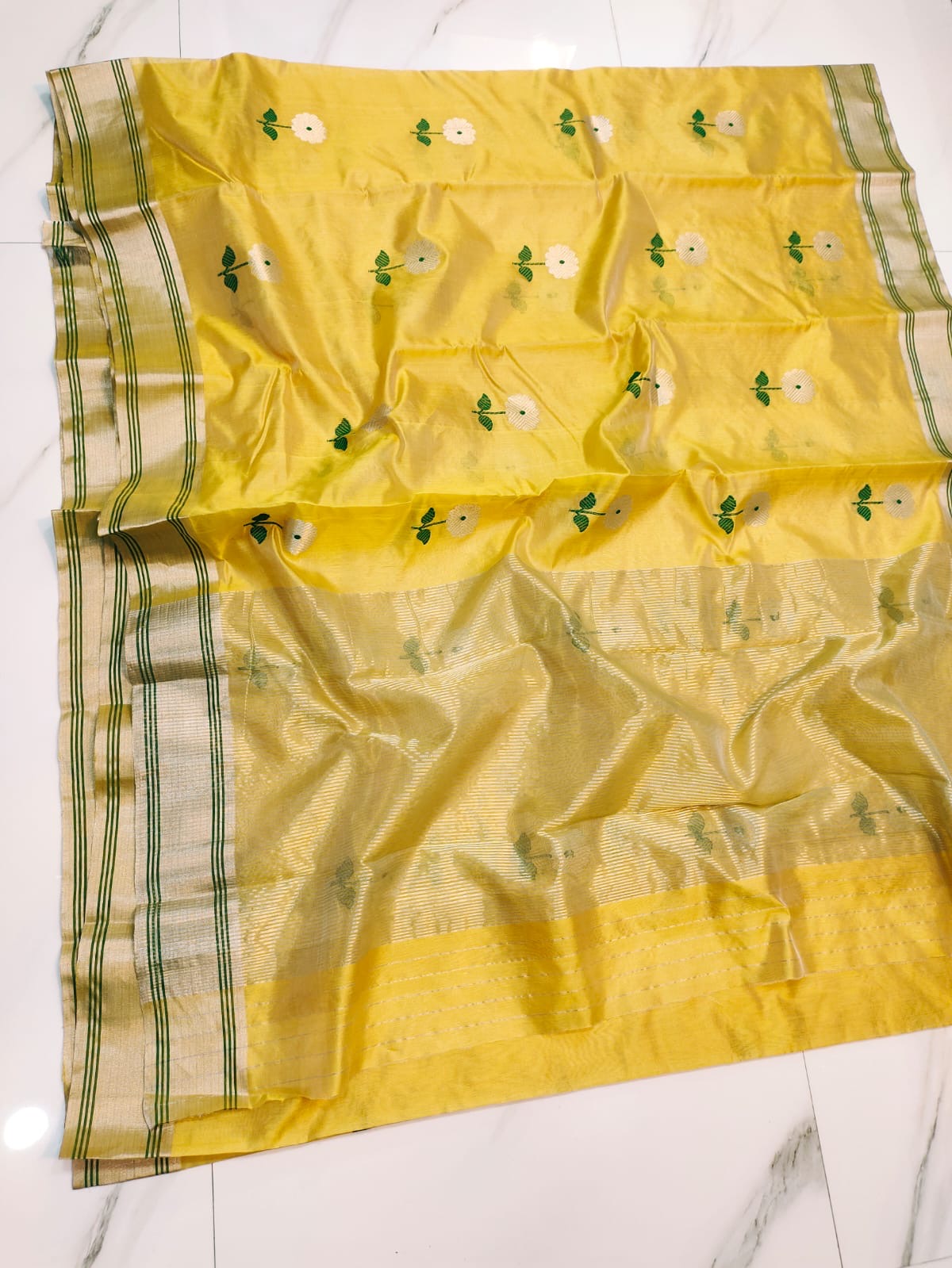 Turmeric Yellow handloom Chanderi saree with repeating silver flowers, green stems and broad pale metallic pallu
