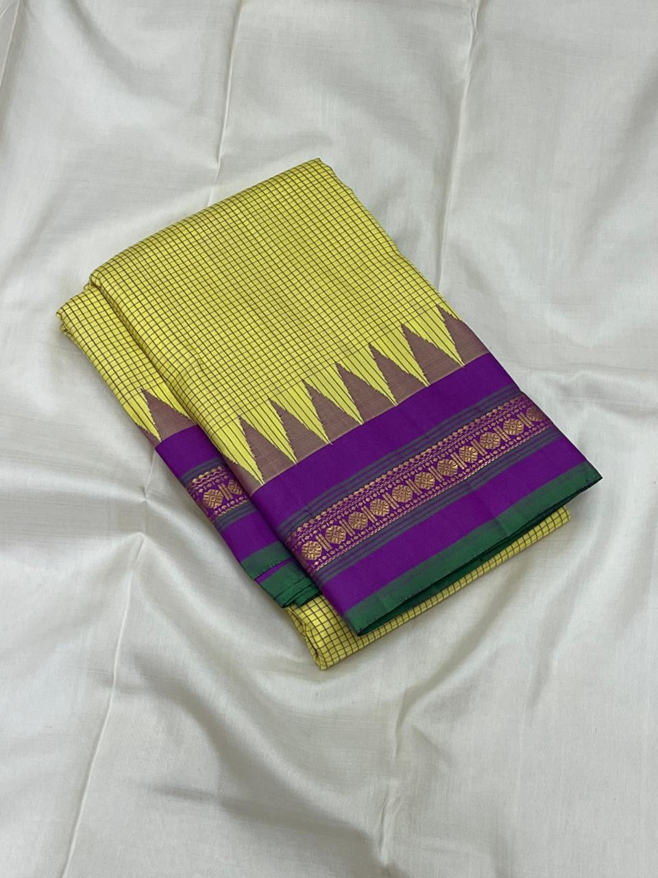 folded chartreuse checked kanchipuram silk saree with purple border and green selvedge