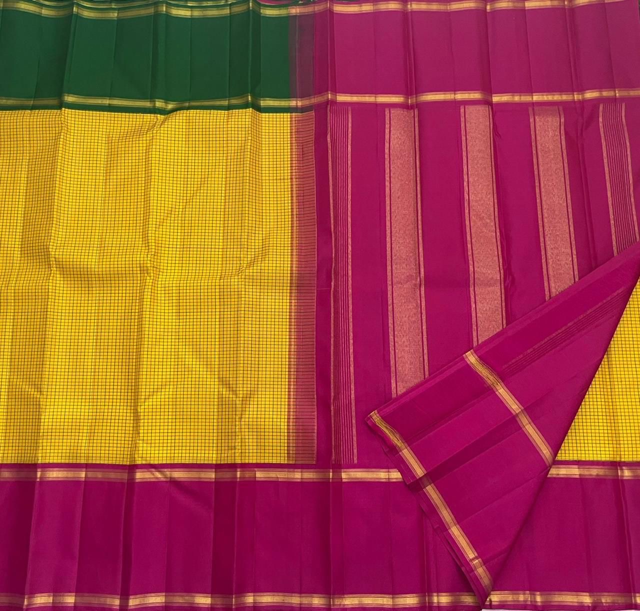 contrast green and magenta zari border detail on sunflower yellow kanchipuram silk saree