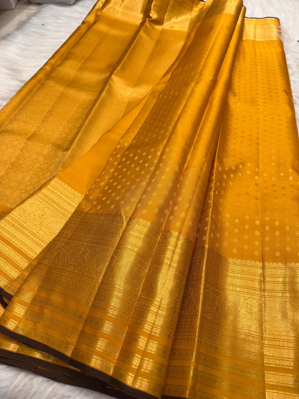 Close view of fine antique-gold zari buttas on Turmeric Yellow Kanjivaram silk.