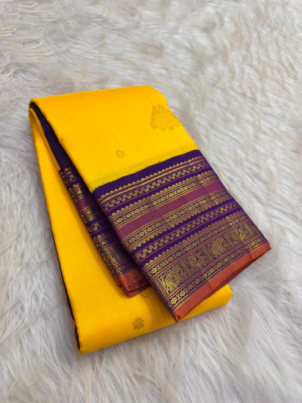 Close view of Kalam paisley buttas on the yellow silk body of a Kanchipuram saree