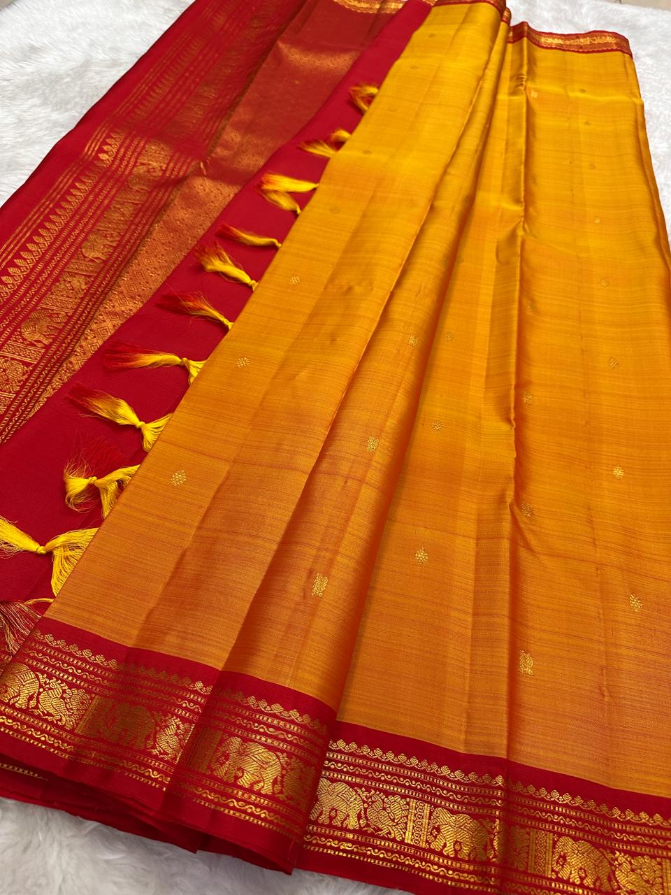 Mango mambazham yellow Kanchipuram silk saree pleated view highlighting subtle antique gold butta and contrast border