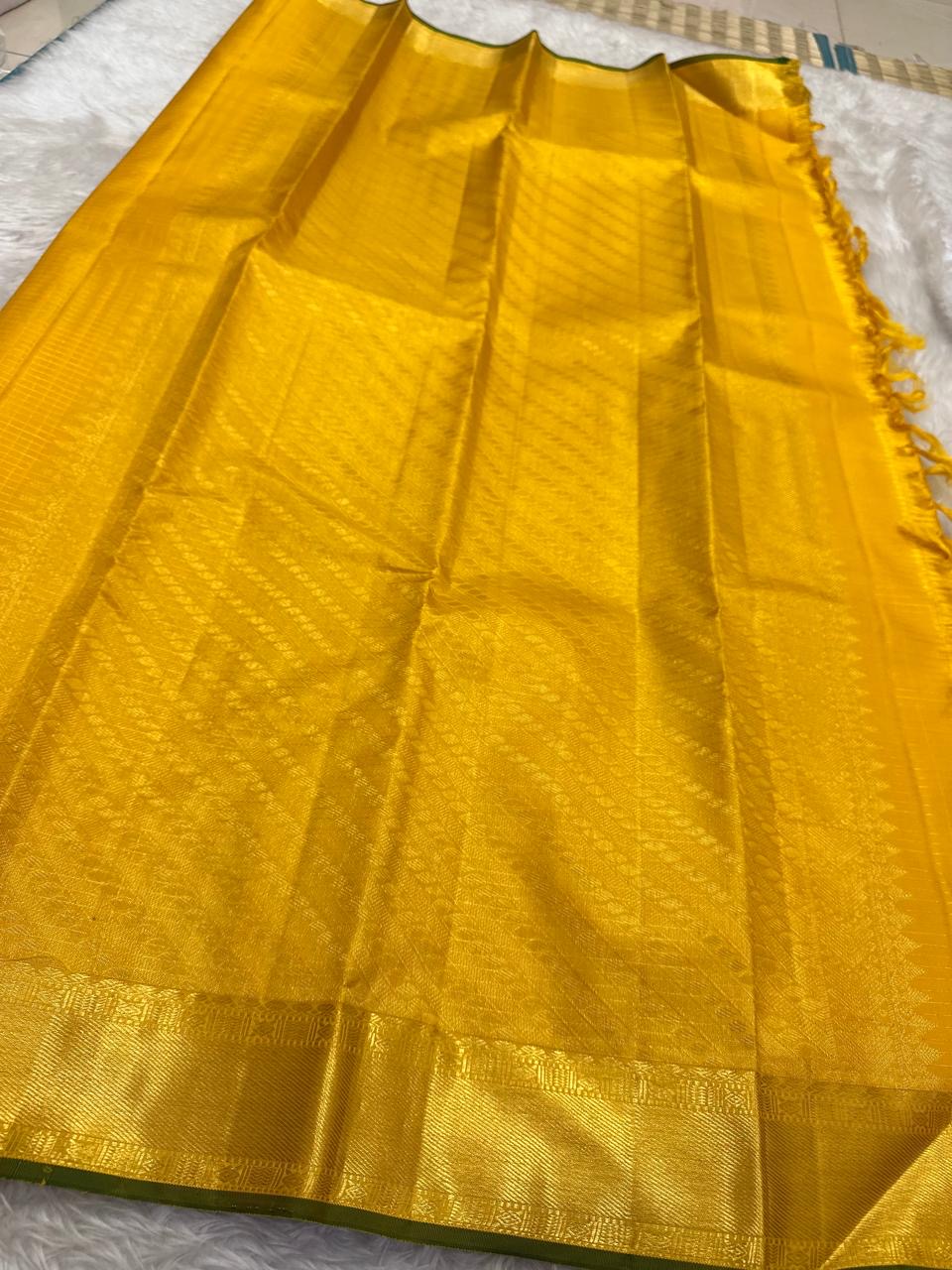 Diagonal zari woven pallu in antique gold cascading across yellow silk ground
