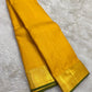 Yellow Kanjivaram saree folded to show Zari Kattam body and antique gold zari border