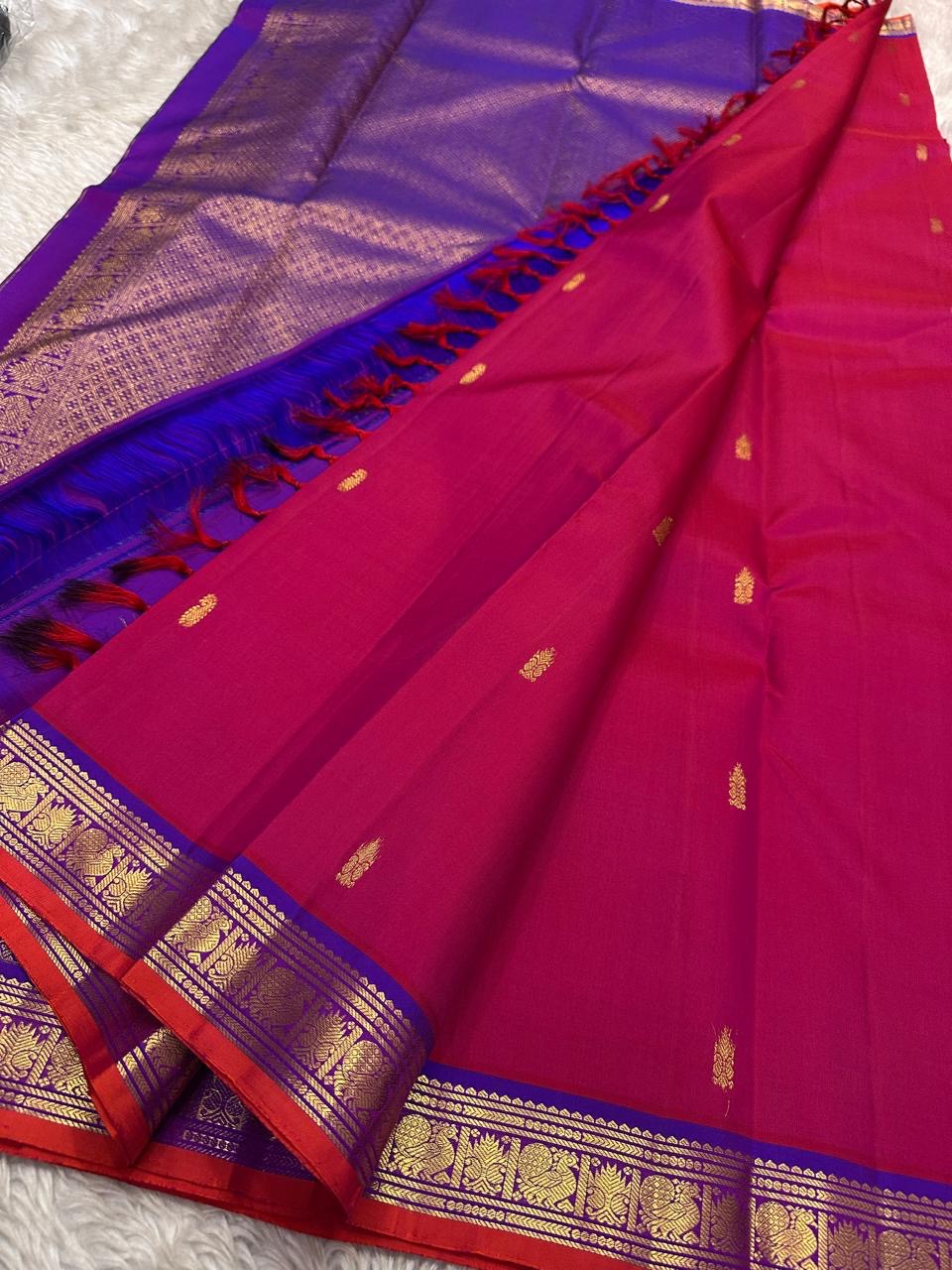 Pure Kanchipuram silk saree with rani pink body, gold zari buttas, blue zari woven border, and royal blue pallu.